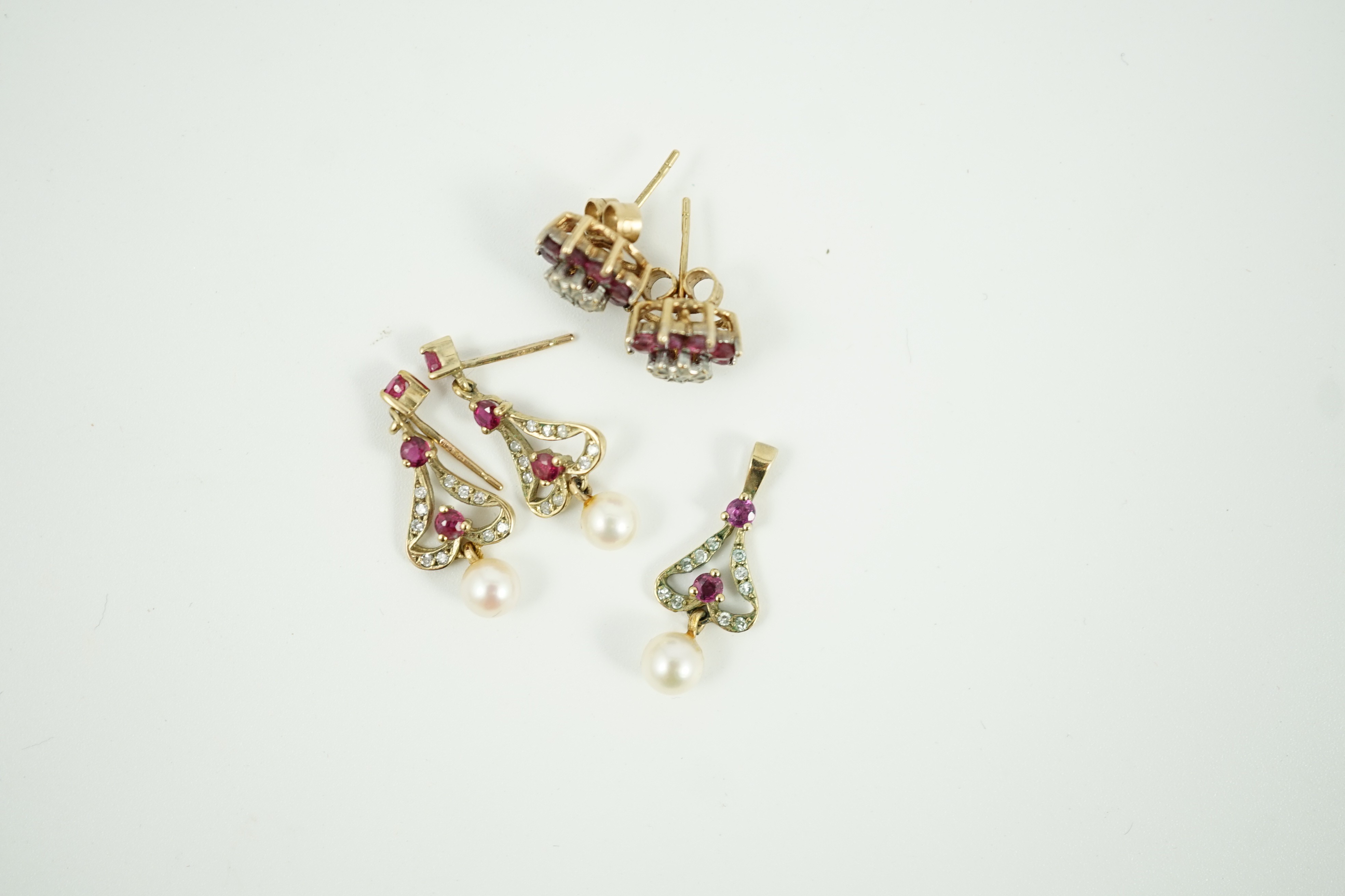A modern 9ct gold, ruby, diamond and cultured pearl set drop pendant, 22mm and a pair of matching earrings, together with a pair of ruby and diamond cluster set ear studs, gross weight 5.7 grams.